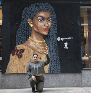 Artist AGonza in front of her mural of Miss Rhode Island, Jonet Nichelle